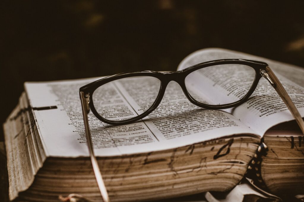 Glasses placed on an open book, representing thoughtful reading and quiet reflection