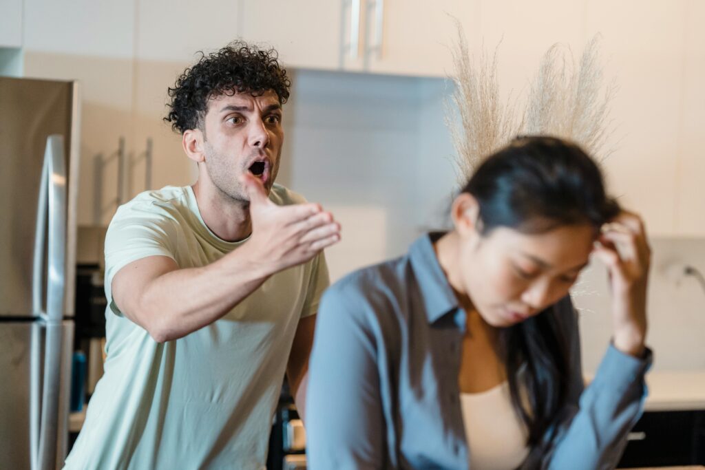 Man yelling at upset woman during a heated argument in the kitchen